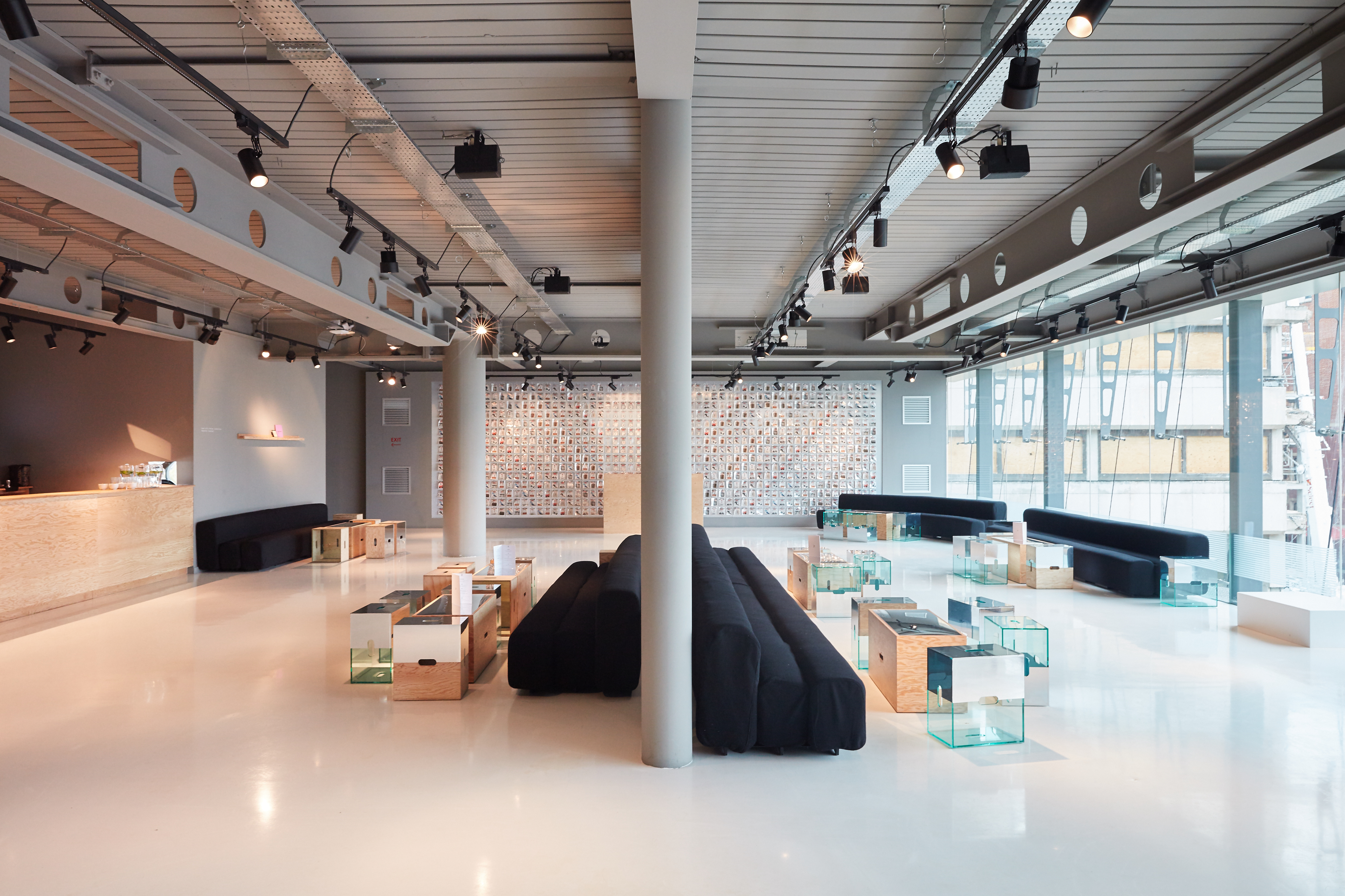 White resin commercial flooring in a large space with black sofas and glass tables