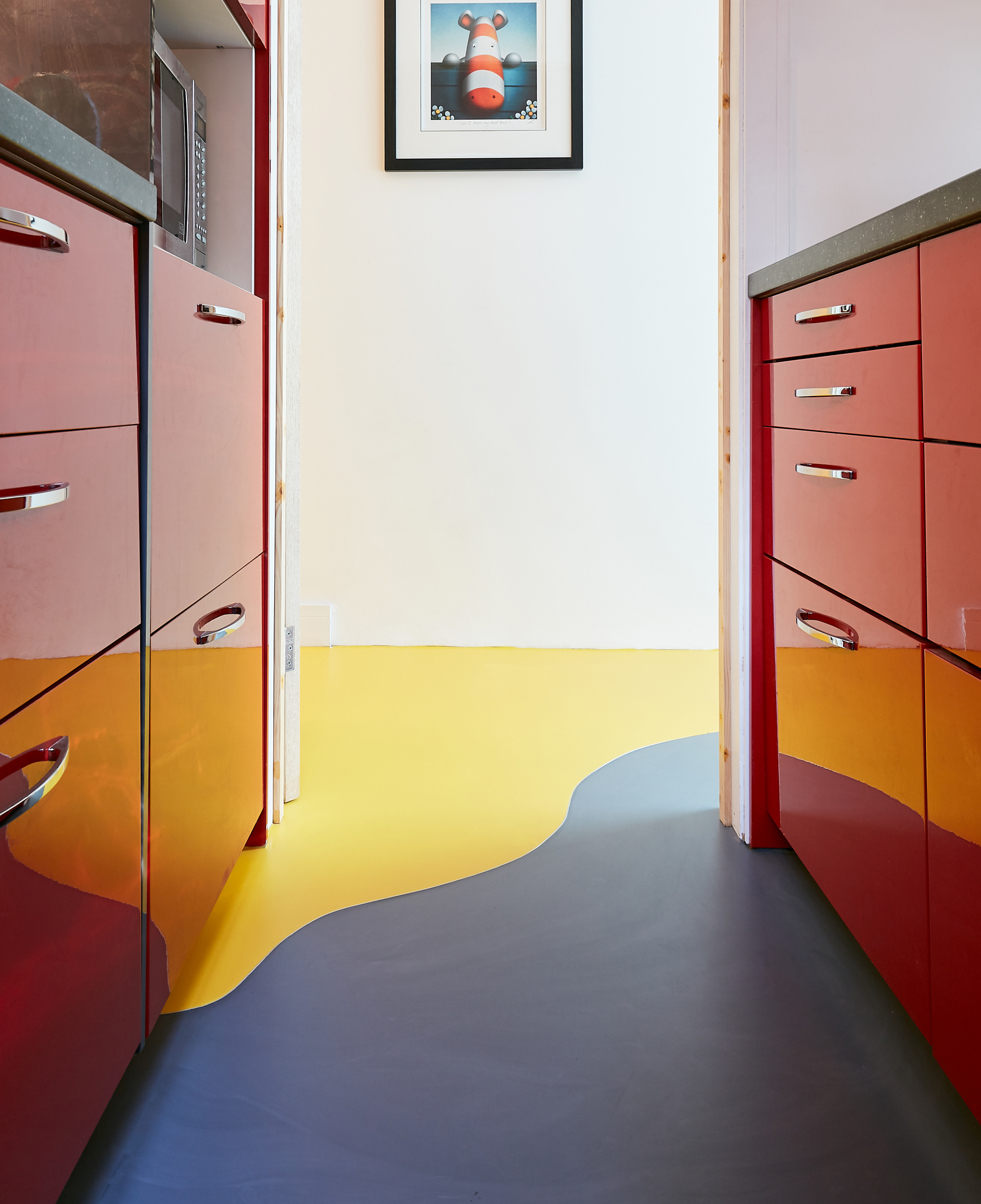 Yellow and grey resin kitchen flooring with red cabinets