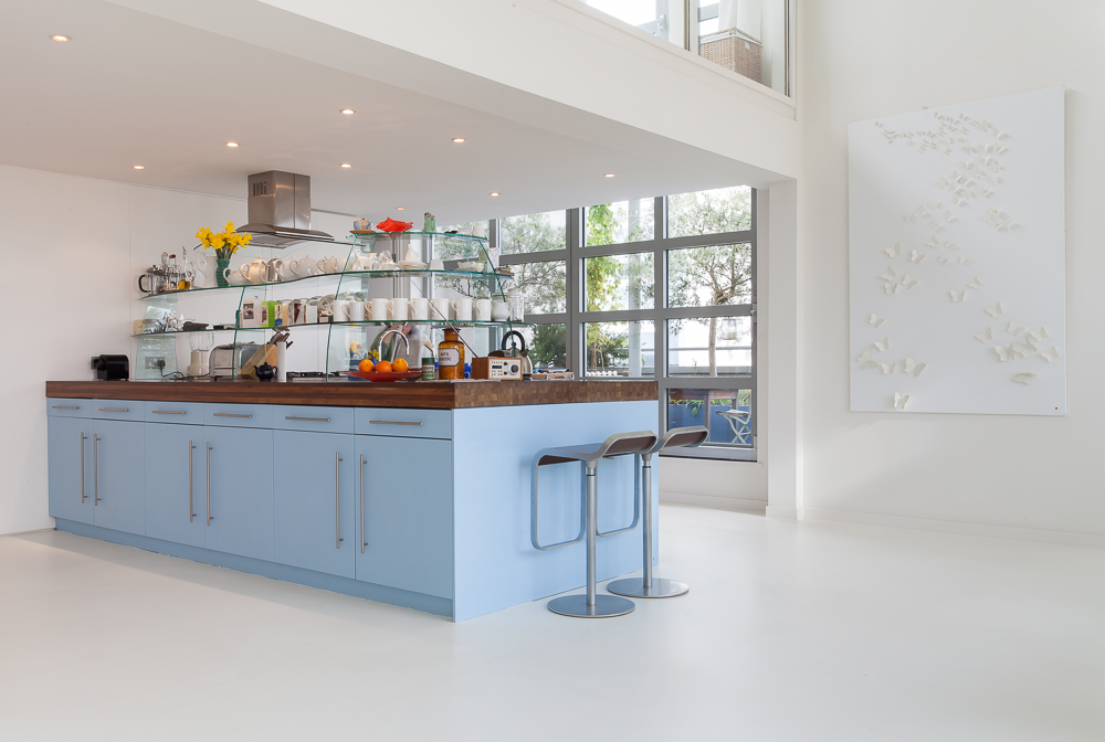 White resin kitchen flooring with blue kitchen island