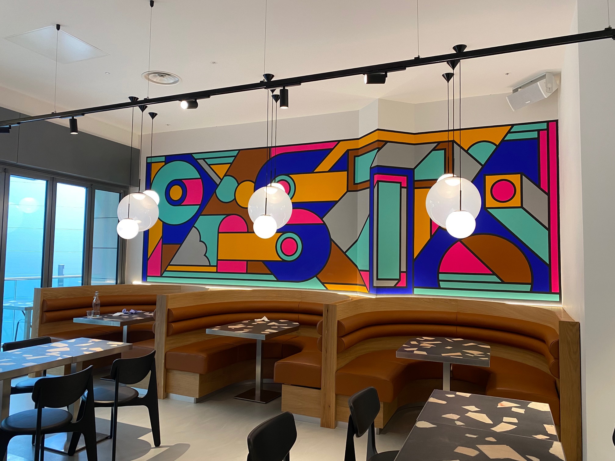 Light grey resin restaurant flooring with multi-coloured backdrop