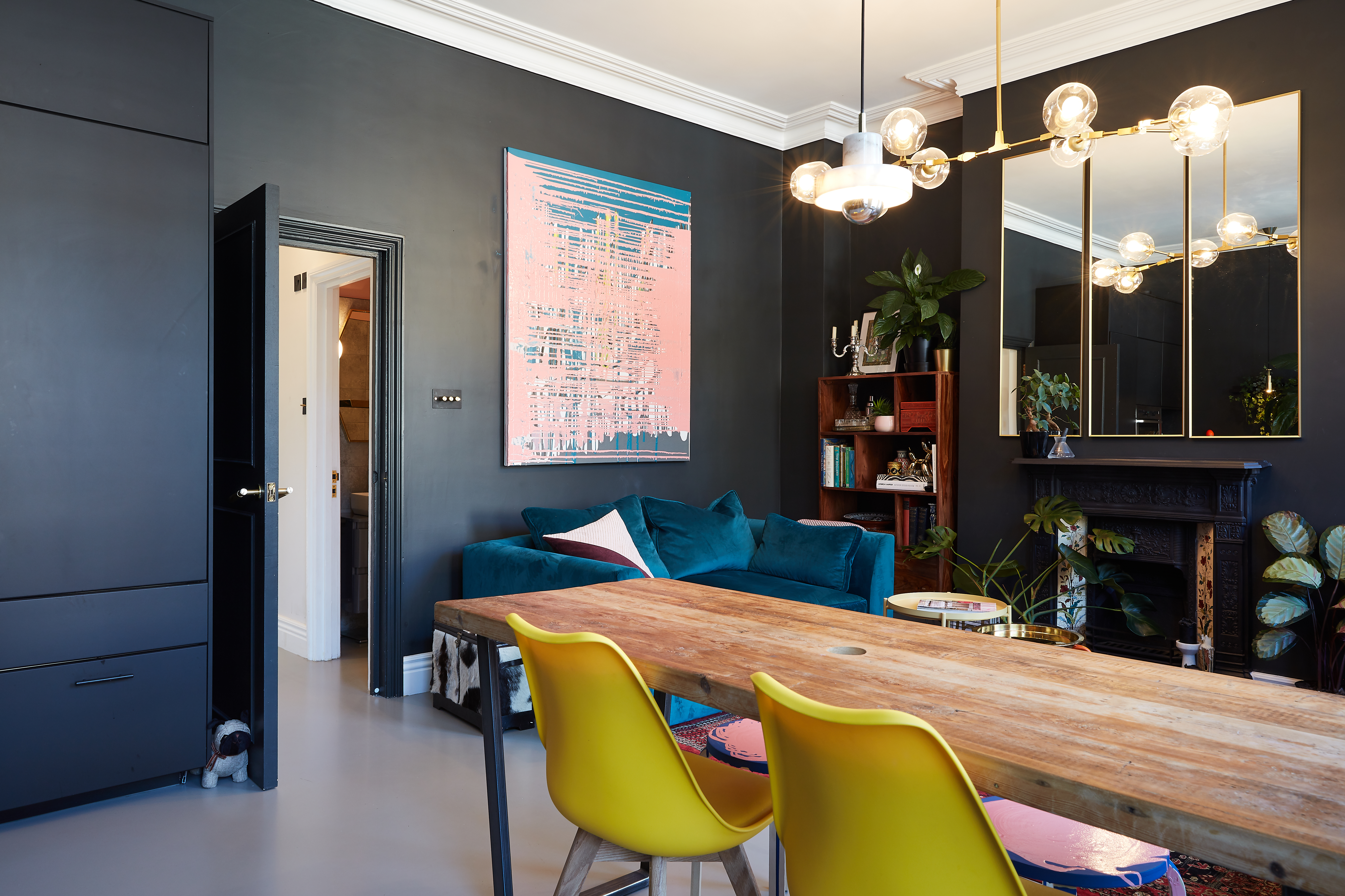 Dark grey resin kitchen flooring with table and chairs and black walls