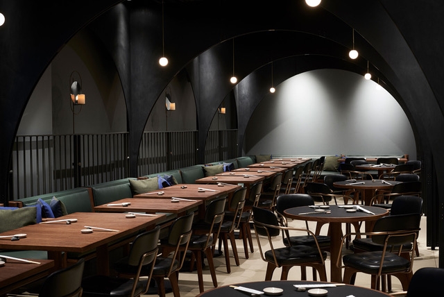 Light grey resin restaurant flooring with long wooden table and chairs