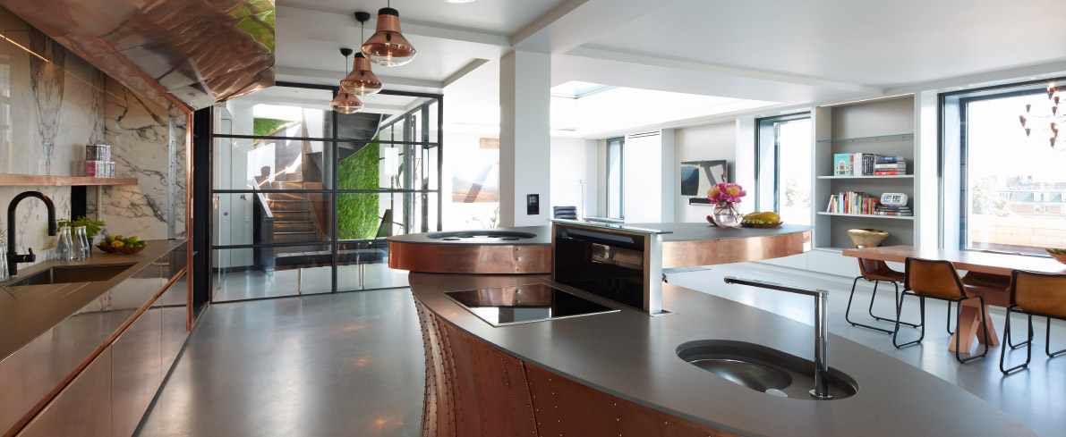 Solid grey resin floor in a kitchen with copper countertops