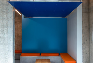 Blue resin floor for student accommodation, with corner sofa and dark blue ceiling