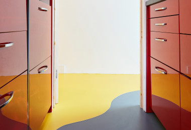 Yellow and grey resin kitchen flooring with red cabinets