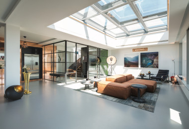 Dark grey resin living room floor with skylight and warm toned furniture