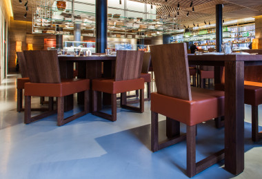 Dark grey resin restaurant flooring with wooden tables and chairs