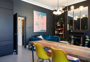 Dark grey resin kitchen flooring with table and chairs and black walls