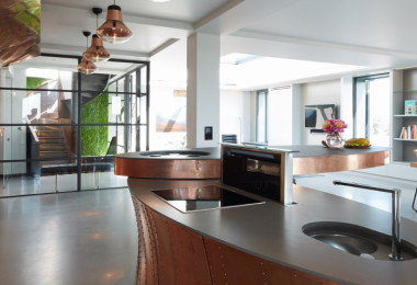 Solid grey resin floor in a kitchen with copper countertops