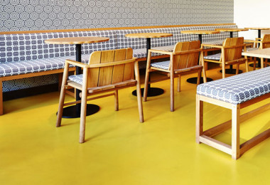 Yellow resin restaurant flooring with wooden and patterned table and chairs