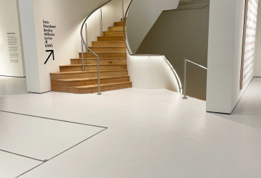 Light grey museum flooring with spiral wooden staircase