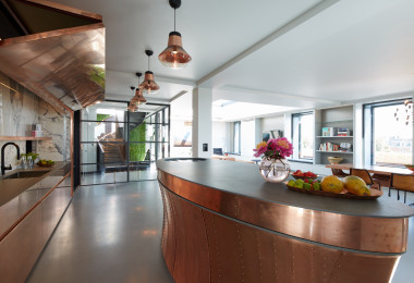 Grey resin kitchen flooring with bronze coloured kitchen island