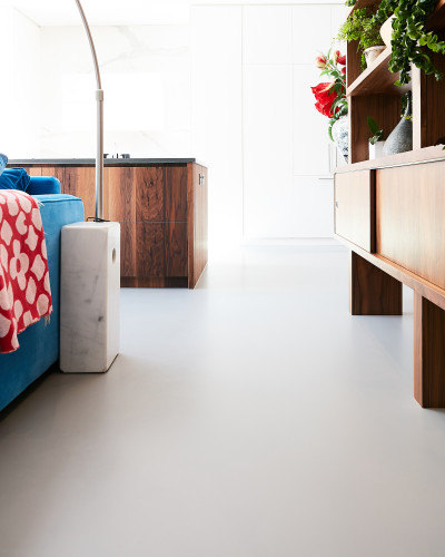 Light grey resin alternative to polished concrete floor in a bedroom