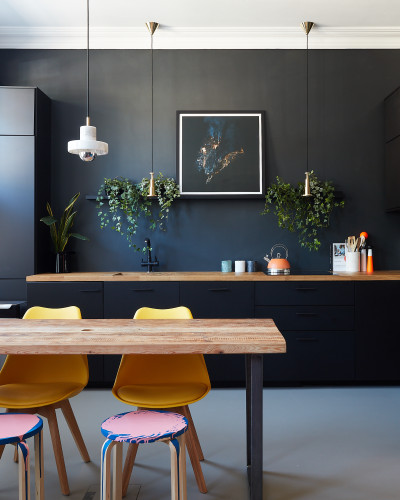 Dark grey resin kitchen floor with table and chairs, and black wall